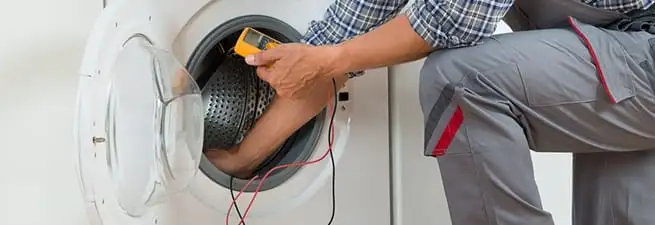 Dryer repair technician inspecting and repairing a clothes dryer in Memphis, TN