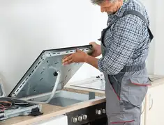 Appliance repair technician installing a built-in cooktop in Memphis, TN