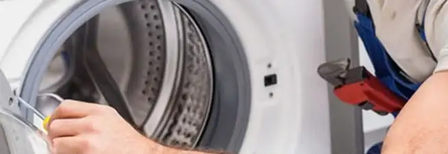 Appliance technician repairing a clothes dryer drum and internal parts in Memphis, TN