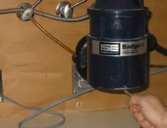 Garbage disposal repair technician tightening the mounting ring under a sink in Memphis, TN
