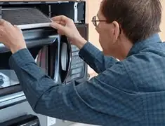 Appliance repair technician replacing a microwave vent filter in Memphis, TN
