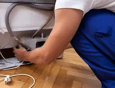 Appliance repair technician fixing refrigerator water line and connections in Memphis, TN
