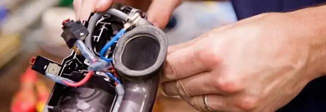 Vacuum repair technician reconnecting wiring and components in Memphis, TN