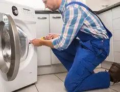 Washing machine repair technician servicing a front-load washer in Memphis, TN