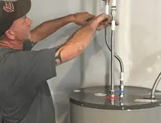 Water heater repair technician tightening supply line connections in Memphis, TN