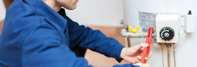 Water heater repair technician adjusting the temperature control and gas valve in Memphis, TN